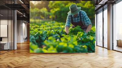 Farmer tending to crops in a lush field during morning light Wall mural