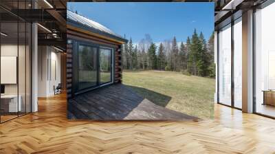 Beautiful contemporary rustic log cabin on a rural field in the mountains Wall mural