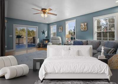 Beautiful suburban house interior with blue walls and sofas under a ceiling fan Wall mural