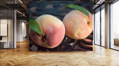 Two Ripe peaches together with a leaf. Wall mural