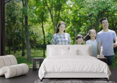 chinese family smiling & walking together in park Wall mural