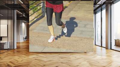 young woman jogging in city park in summer Wall mural