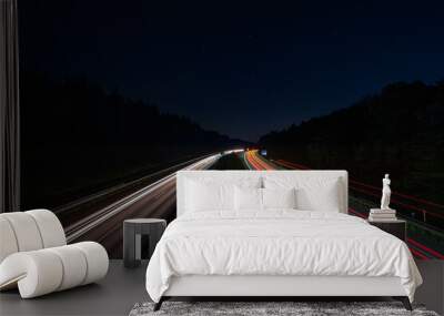 Lighttrails of a traffic motorway from the cars front and headlights, passing fast the point ov view. Wall mural