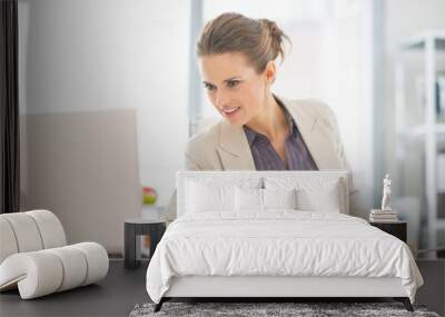 Business woman working with laptop in office Wall mural