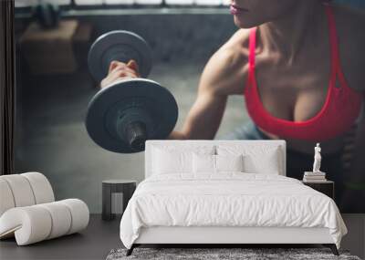 Closeup on fitness woman lifting dumbbell in loft gym Wall mural