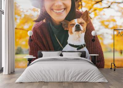 Closeup on happy young woman with dog outdoors in autumn Wall mural