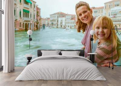 Happy mother and baby girl travel by venice water bus Wall mural