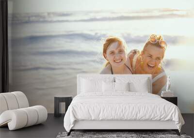 happy mother and teenage daughter at beach having fun time Wall mural