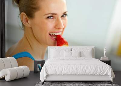 happy young woman eating strawberry Wall mural