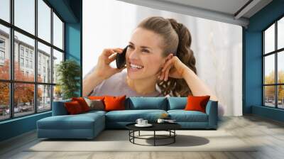 Happy young woman talking mobile phone Wall mural