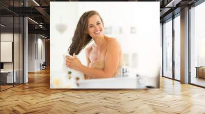 Happy young woman wiping hair with towel Wall mural