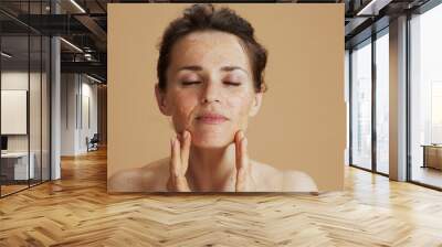 modern woman with face scrub isolated on beige Wall mural