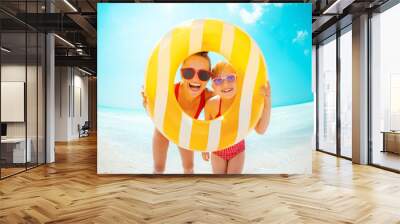 mother and child looking through yellow inflatable lifebuoy Wall mural