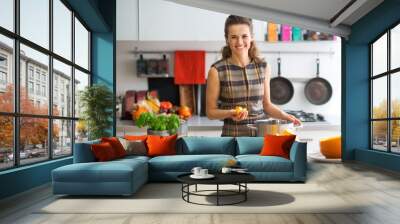 portrait of happy young housewife cooking pumpkin Wall mural