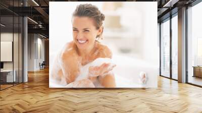 portrait of happy young woman playing with foam in bathtub Wall mural