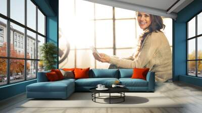 Portrait of happy young woman with tablet pc in loft apartment Wall mural