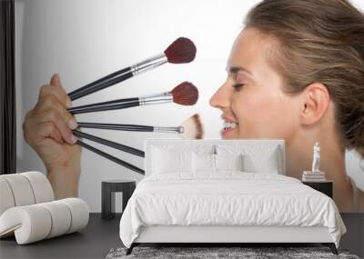 profile portrait of happy young woman with makeup brushes Wall mural