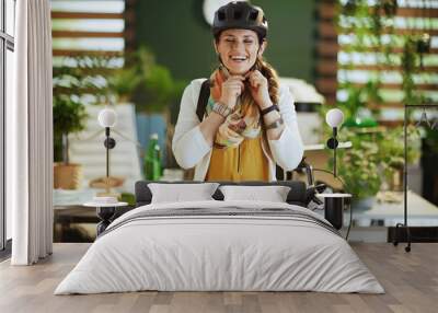 smiling elegant business woman in bike helmet in eco office Wall mural