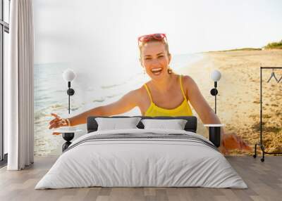 smiling modern woman on beach in evening having fun time Wall mural