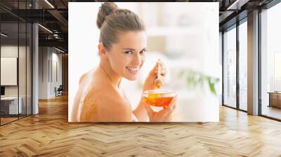 Smiling young woman enjoying honey spa therapy Wall mural