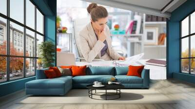 thoughtful business woman documents in office Wall mural