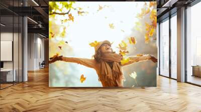 woman enjoying autumn and catching falling yellow leaves Wall mural