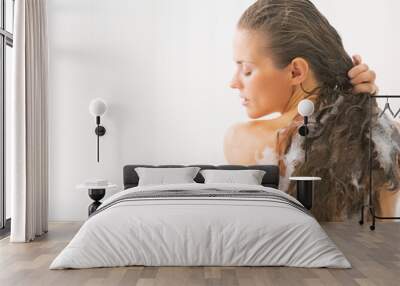 Young woman washing hair in bathtub Wall mural