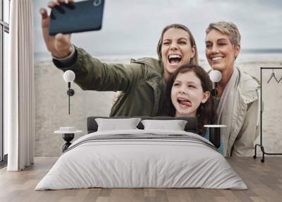 Beach, grandma and child selfie with phone for happy family holiday break together in Canada. Mother, daughter and grandmother capture joyful picture for social media on ocean leisure walk. Wall mural