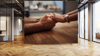 Couple holding hands in support, grief and healing together on a wooden table at home. Closeup of a caring partner in sorrow due to cancer and expressing feelings of compassion in a house Wall mural