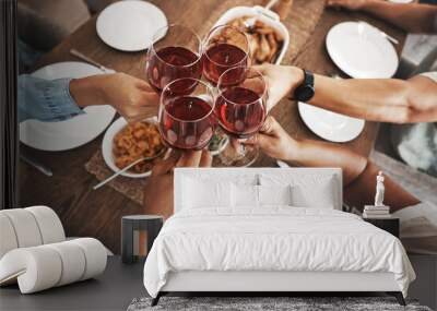 Top view, hands and toast with red wine at dinner table for new year celebration in home. Party, cheers and group of friends, men and woman with alcohol or beverage to celebrate with delicious food. Wall mural