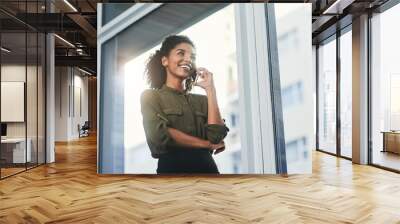 Exciting prospects on the horizon. Shot of a young businesswoman making a phone call in her office. Wall mural