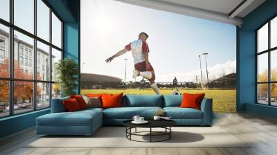 Football, training and kick with man on field playing for sports, fitness and goals strike. Exercise, workout and soccer ball with athlete on grass for health, wellness and competition games Wall mural