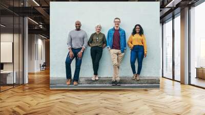 Nothing can stand in our way. Full length shot of a group of businesspeople standing in line against a wall outdoors. Wall mural