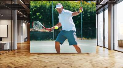 Staying healthy is a lifestyle. Cropped shot of a handsome mature man playing tennis alone on a court during the day. Wall mural