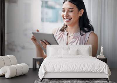 Technology eases the work load. Shot of an attractive young businesswoman standing alone in the office and using a digital tablet. Wall mural