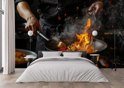 The chef in black uniform cooking thai food in hot wok pan. Flames. Dark background Close Up. Wall mural