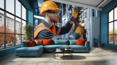 Electrician wearing safety uniform, eyeglasses and hard hats working in a switchboard with an electrical connecting cable. Industrial electric panel repair. Wall mural