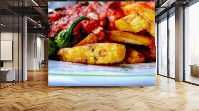 french fries covered with hot organic  tomato sauce closeup in the white plate Wall mural