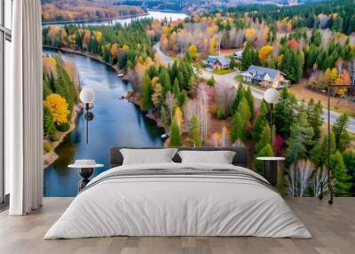 Aerial: view from above the bend of the river and the roofs of private households in the forest on the coastline. Coniferous evergreen and lifeless deciduous trees on the opposite banks in late autumn Wall mural