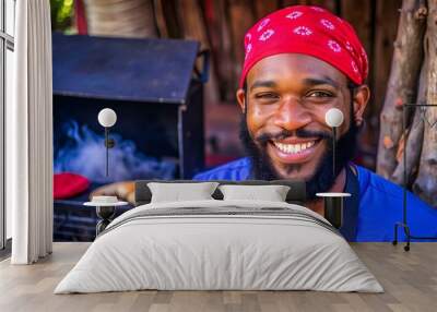 Imagen horizontal de un sonriente hombre afrocaribeño de barba solo  con un pañuelo rojo en su cabeza, al aire libre en su pequeño negocio de venta de carne asada.  Wall mural