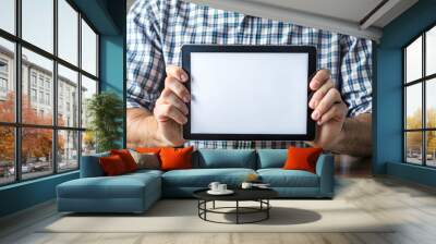 Male hands holding tablet with blank white empty screen, concept of technology use in everyday life, mockup tablet Wall mural