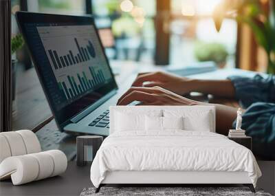 A person working on a laptop with graphs and charts displayed on the screen, representing data analysis, business intelligence, and a modern professional environment focused on data-driven decision-ma Wall mural