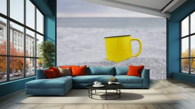 Cup in trendy illuminating color on sand  Wall mural