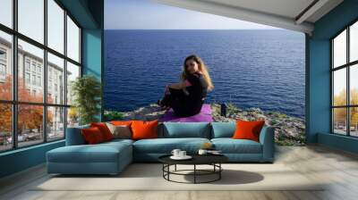 Beautiful young happy lonely girl watching the Mediterranean sea and relaxing Wall mural