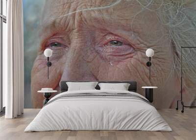 An old woman crying frantically. Tears in the eyes of an old wrinkled grandmother. Pain, disappointment, depression, loneliness, old age. Wall mural