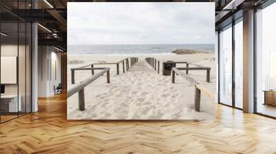 Beautiful sandy beach by the ocean on a cloudy day Wall mural