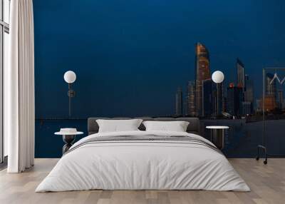 Evening beach overlooking the metropolis of Abu Dhabi, UAE. Twilight and modern buildings Wall mural