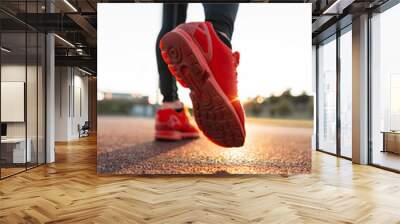 fashionable sporty man with stylish sportswear in red sneakers walks at sunset, close-up. guy runnin Wall mural