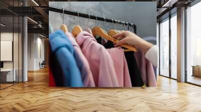 Female hand chooses clothes for today. Colorful fashion clothes set concept. Choice of stylish clothes Wall mural