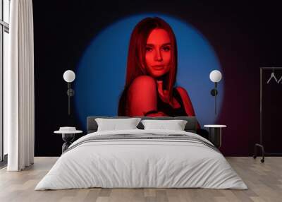 Stylish studio color creative female portrait of a beautiful stylish woman in fashionable clothes with red light on a dark background Wall mural